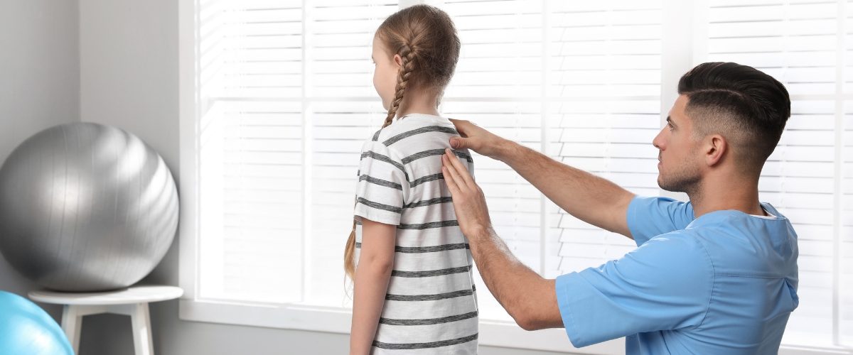 criança com escoliose consultando